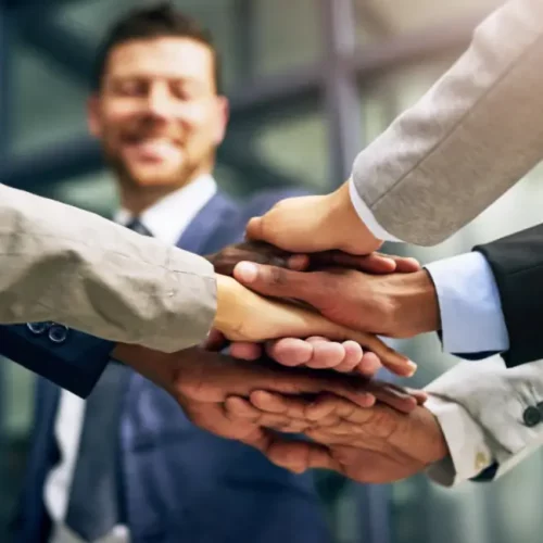 Die Hände von verschiedenen Netzwerkpartnern übereinander als Symbol des starken Netzwerks von Immoversum24